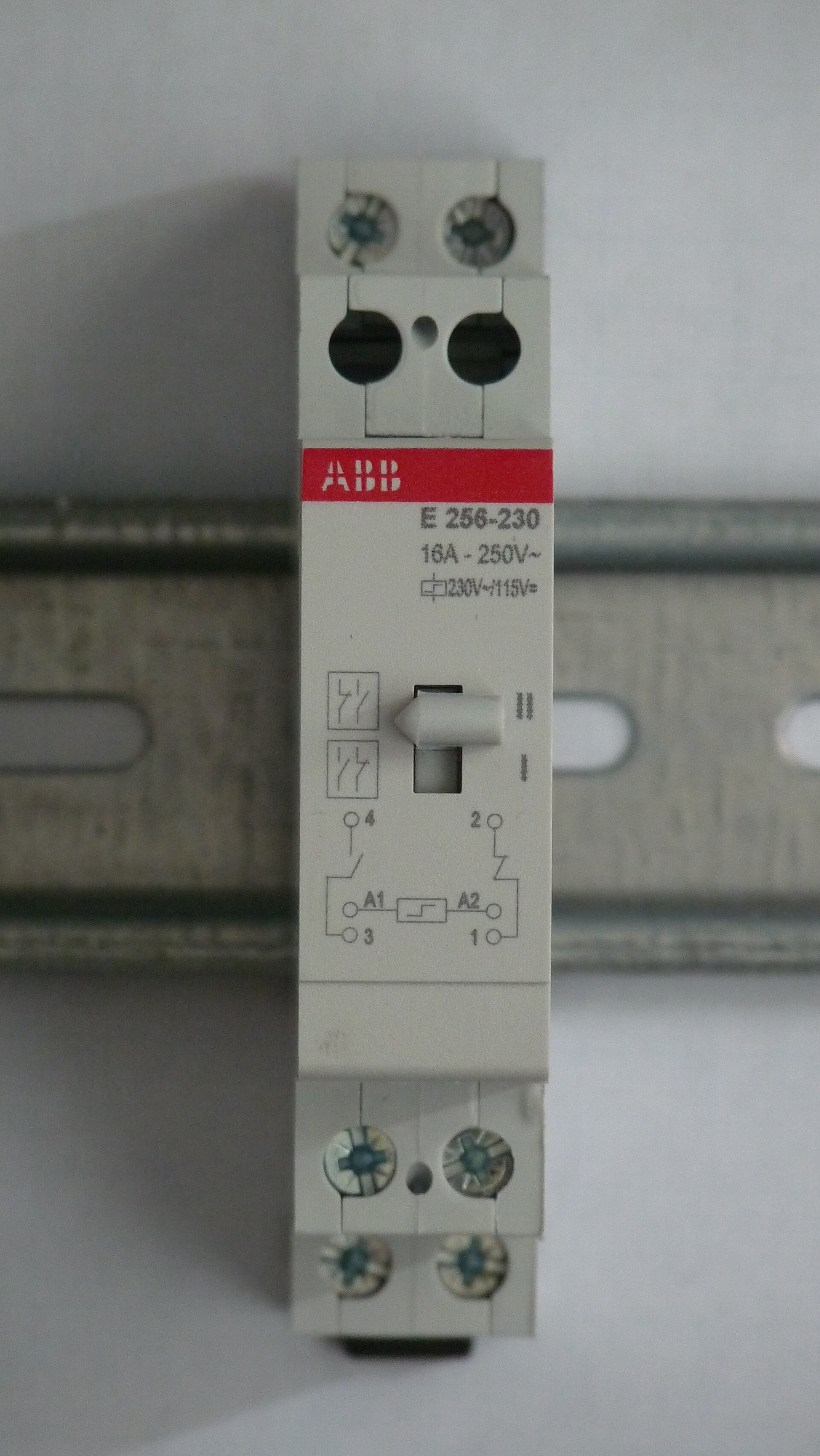Telerruptor modular de 16 A montado en carril DIN con su esquema de bobina A1-A2 impreso en el frontal